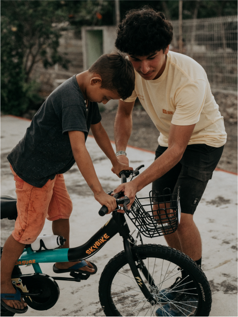 A man helping a child on a bike