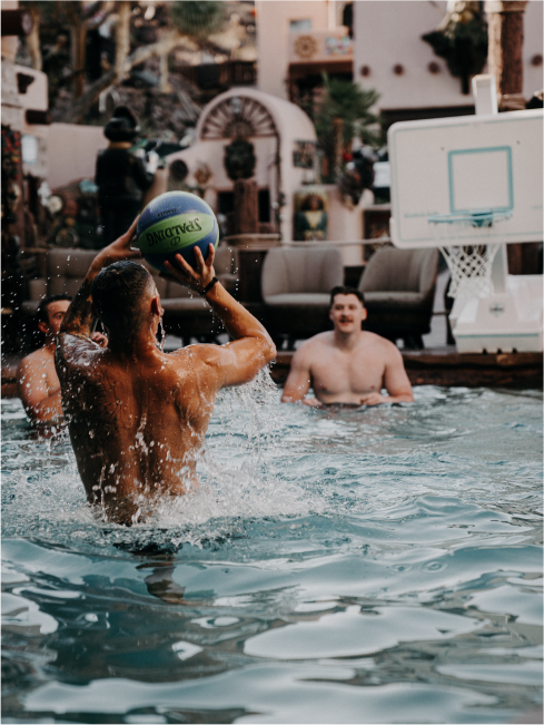 A game of water polo. A man is ready to shoot the ball