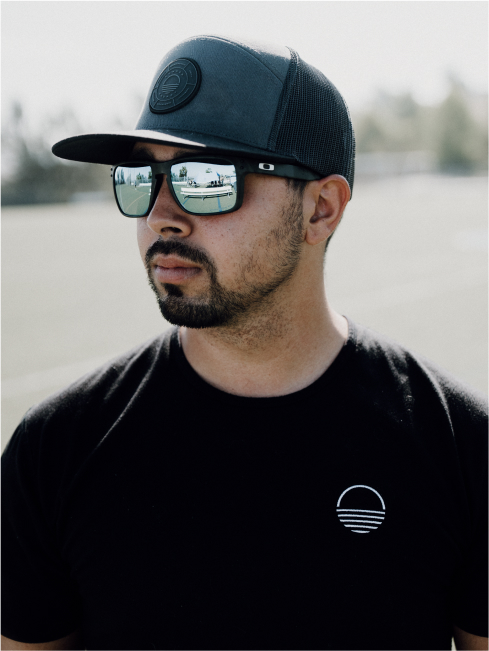 A man with a black shirt, hat, and sunglasses